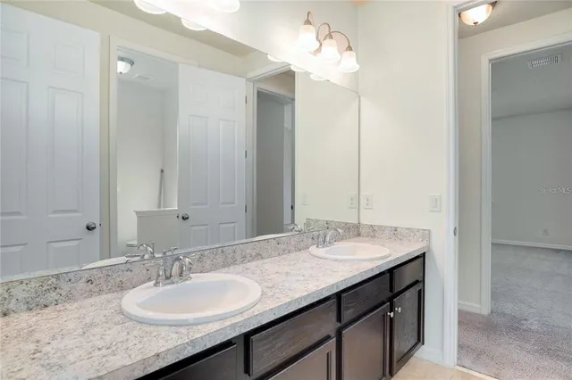 a bathroom with a granite countertop sink and a mirror