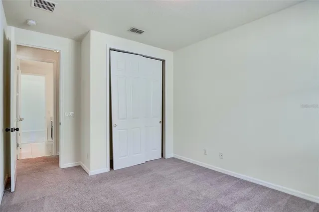 an empty room with closet and a bathroom
