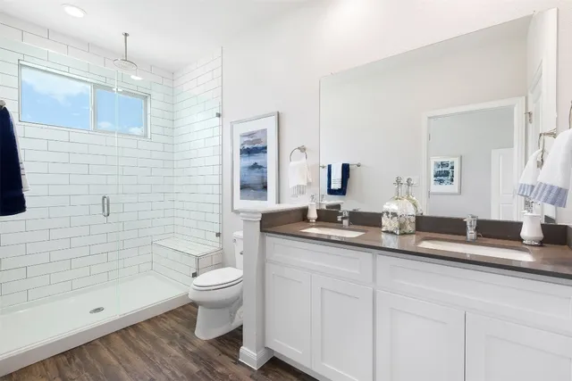 a bathroom with a double vanity sink toilet and shower