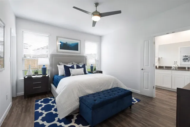 a spacious bedroom with a bed and wooden floor