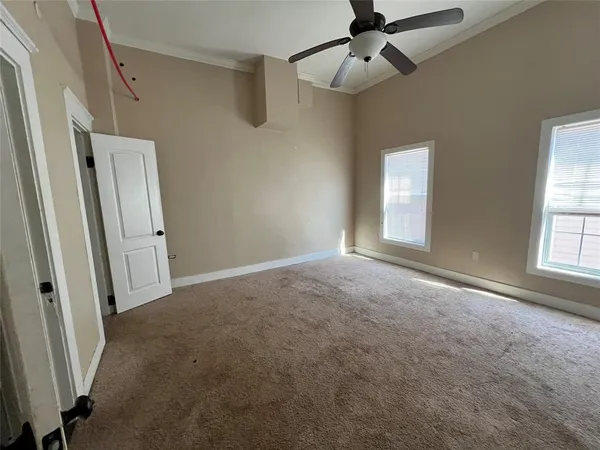an empty room with windows and fan