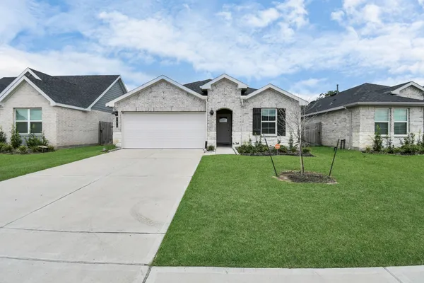 a front view of a house with a yard and trees
