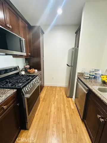 a kitchen with wooden floor and a stove top oven