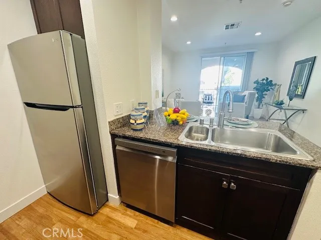 a kitchen with stainless steel appliances granite countertop a refrigerator and a sink