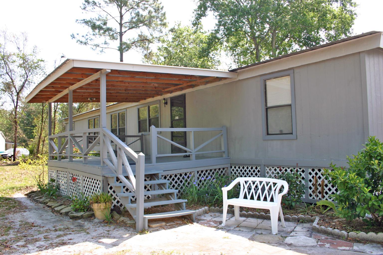 16231 Shark Road West Jacksonville, FL 32226 - Photo 2 of 10 a wooden bench sitting in front of a house