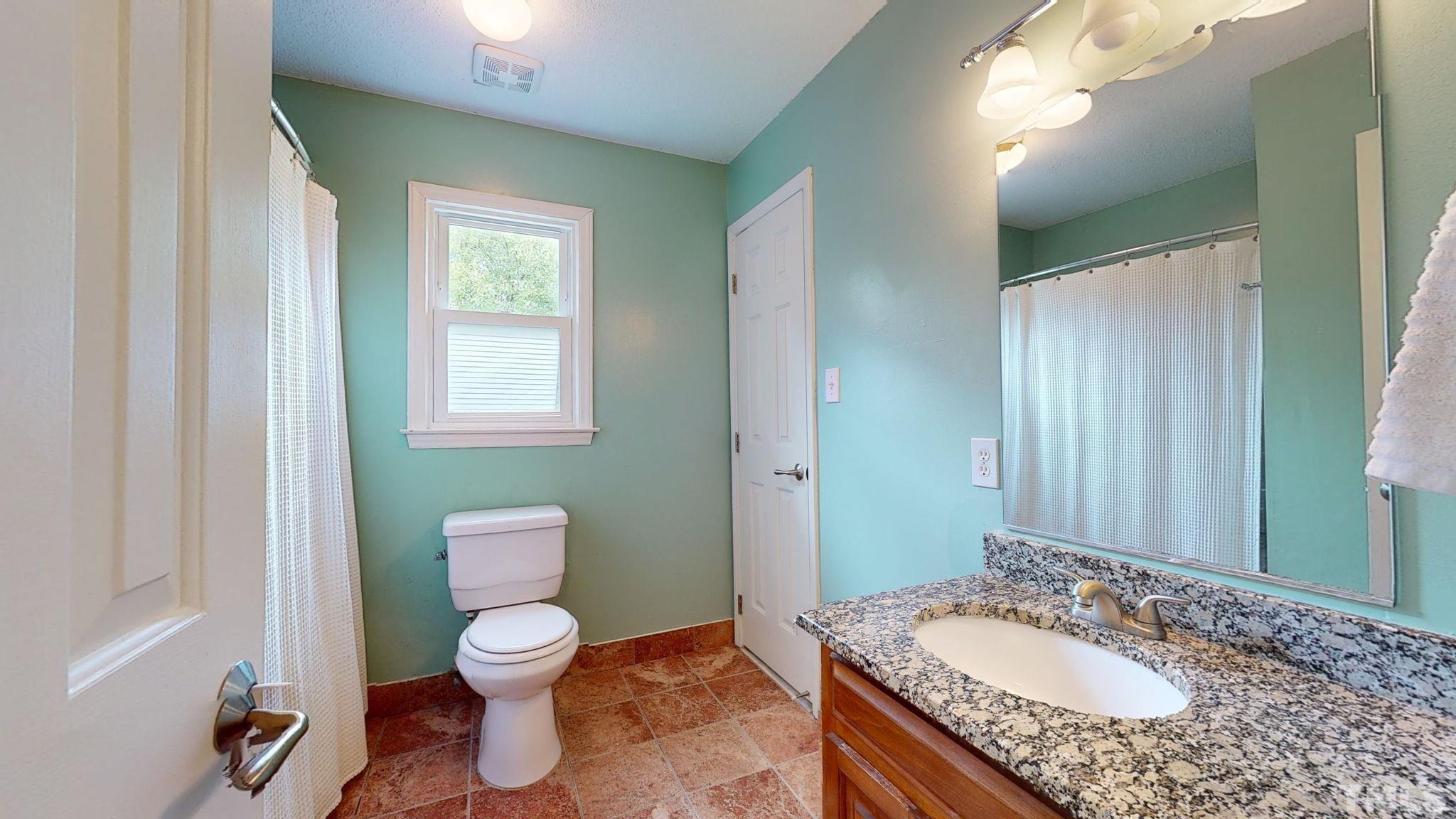 3308 Gatcombe Place Raleigh, NC 27604 - Photo 24 of 43 a bathroom with a granite countertop toilet a sink and a mirror