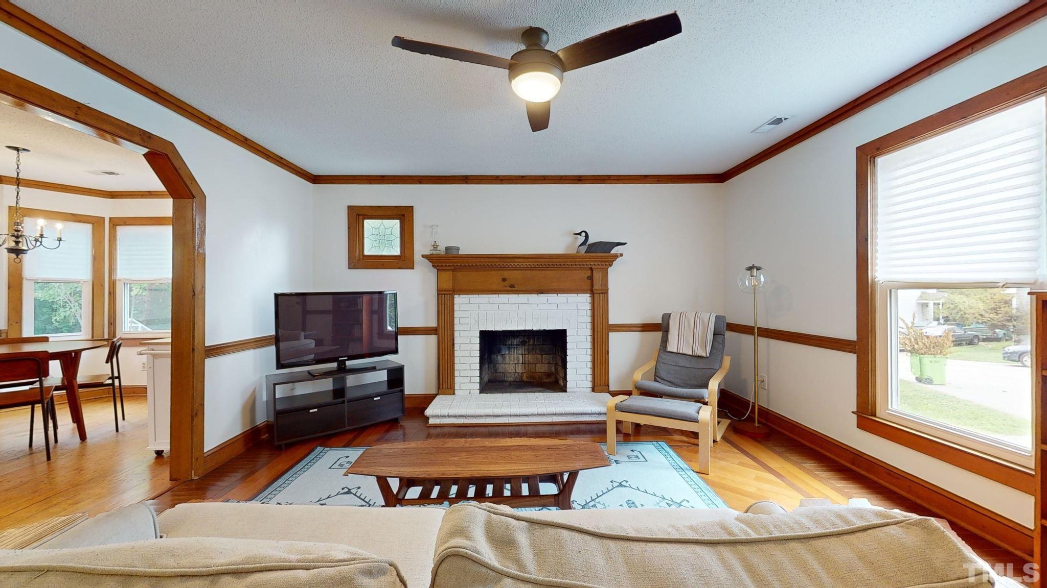 3308 Gatcombe Place Raleigh, NC 27604 - Photo 6 of 43 a living room with furniture a fireplace and a flat screen tv
