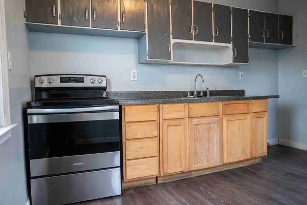 a kitchen with granite countertop white cabinets and stainless steel appliances