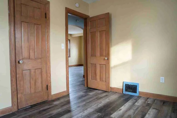 an empty room with wooden floor and closet