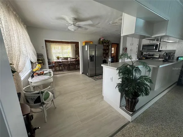 a living room with furniture a large window and potted plants