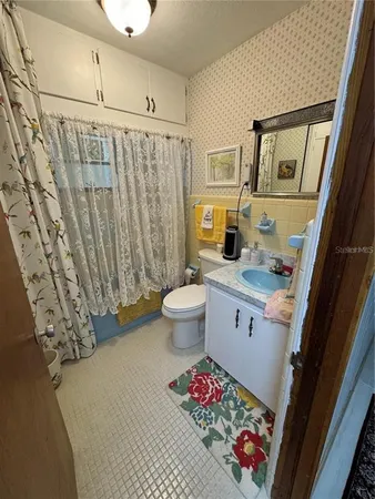a bathroom with a sink a toilet and shower curtain
