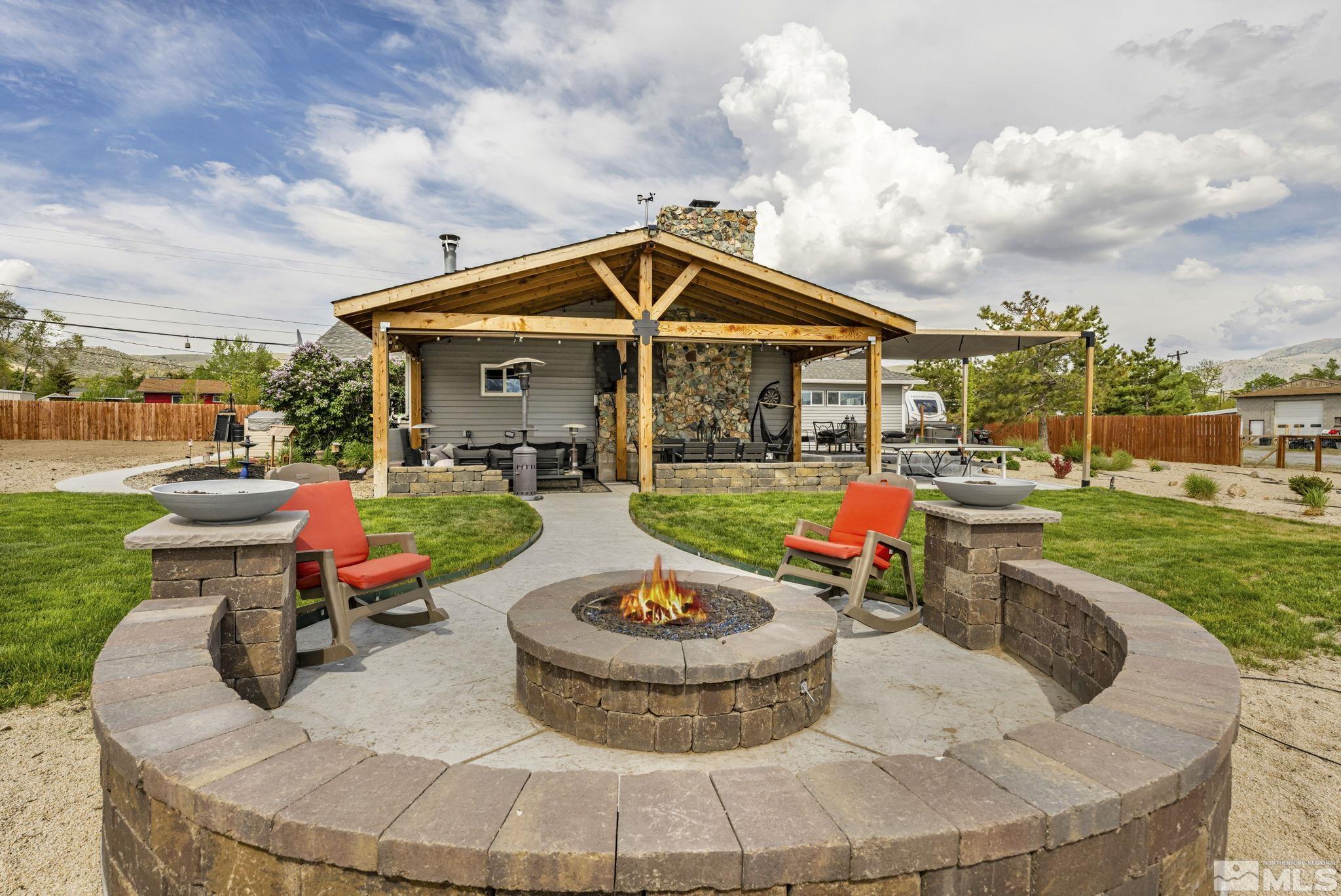 a view of a backyard with sitting area and fire pit