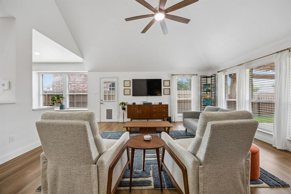 9217 Inverness Drive Rowlett, TX 75089 - Photo 12 of 40 Relaxed Living with Natural Light — Large windows fill the family room with sunlight while the open layout keeps the kitchen, living area, and backyard access within easy reach.