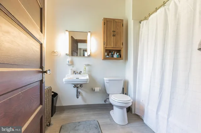a bathroom with a toilet a sink and a mirror