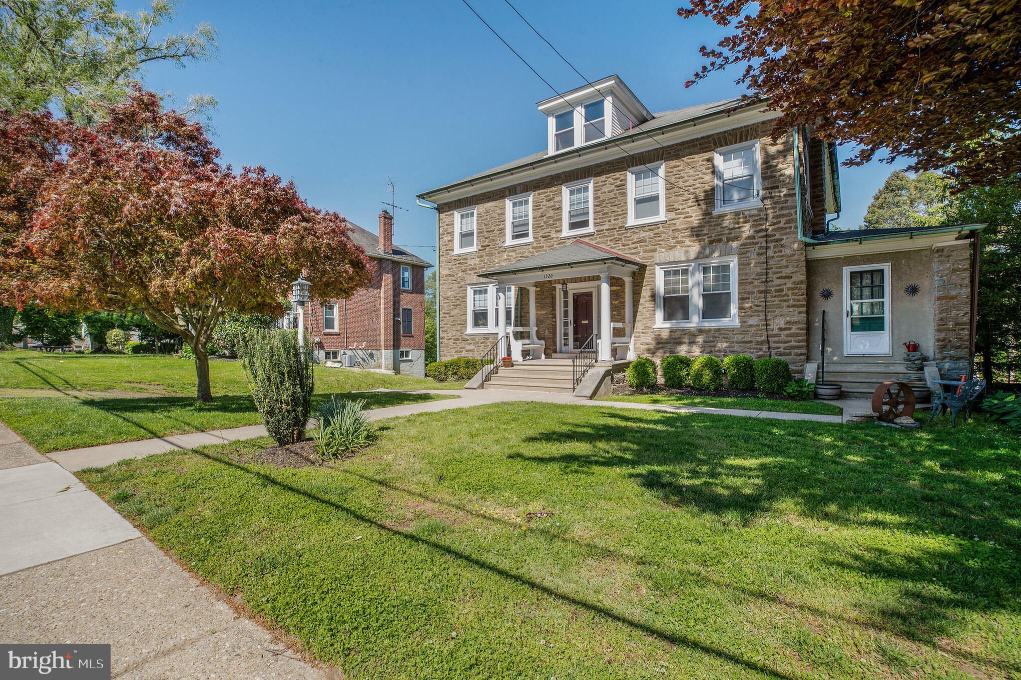 1320 Butler Pike, Unit 2 Conshohocken, PA 19428 - Photo 2 of 18 a front view of a house with a yard table and chairs