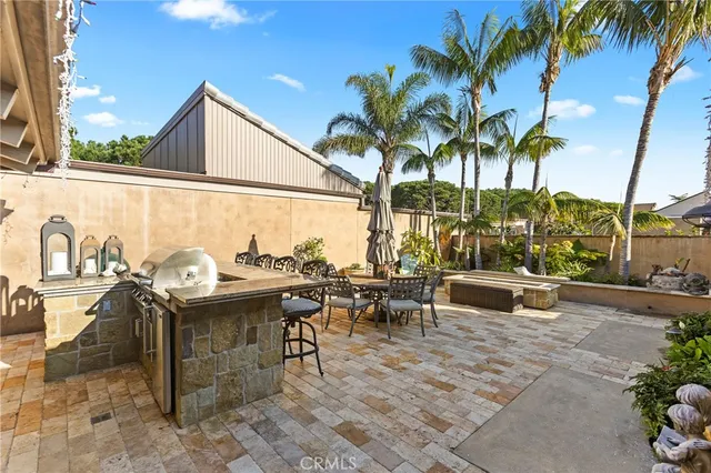 a view of a patio with table and chairs potted plants and palm tree