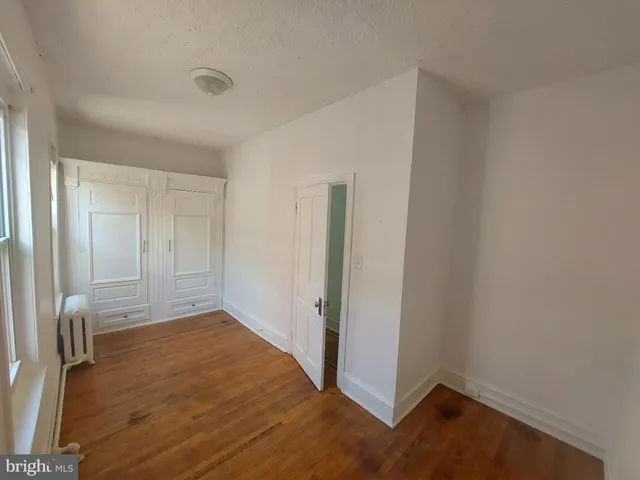 an empty room with wooden floor and closet