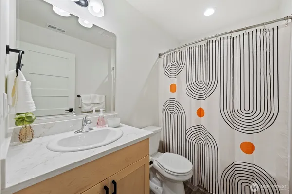 a bathroom with a sink a toilet and a mirror
