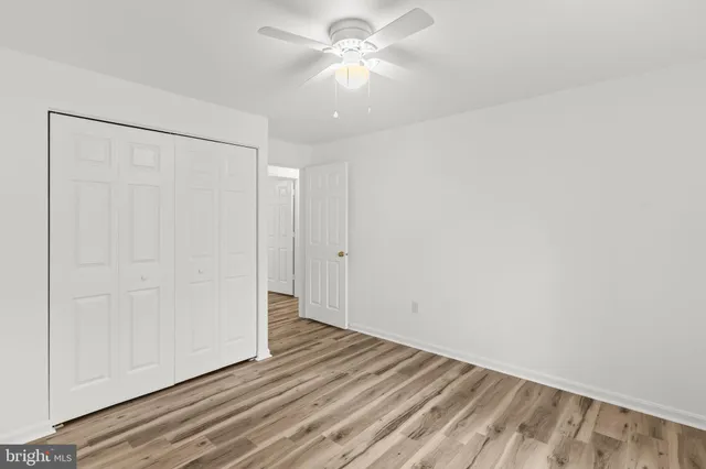 a view of a room with wooden floor and a ceiling fan