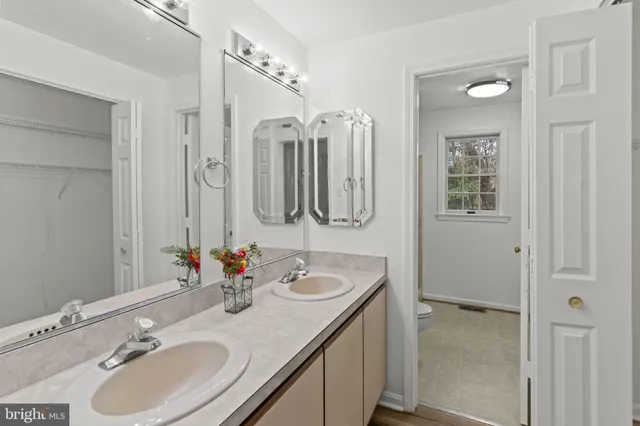 a bathroom with double vanity sinks and a mirror