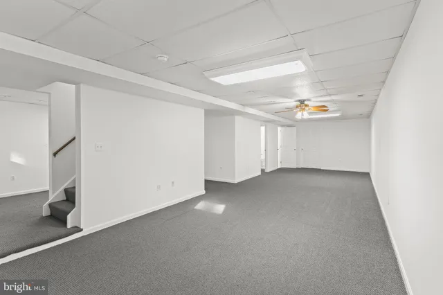 an empty room with a window and a ceiling fan