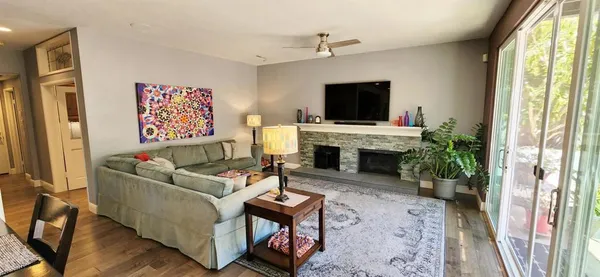 a living room with furniture a flat screen tv and a fireplace