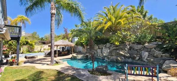 a front view of a house with garden and sitting area