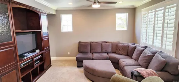 a living room with furniture a flat screen tv and a window