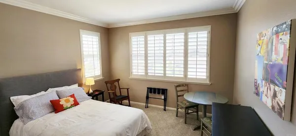 a bedroom with a bed chair and a window