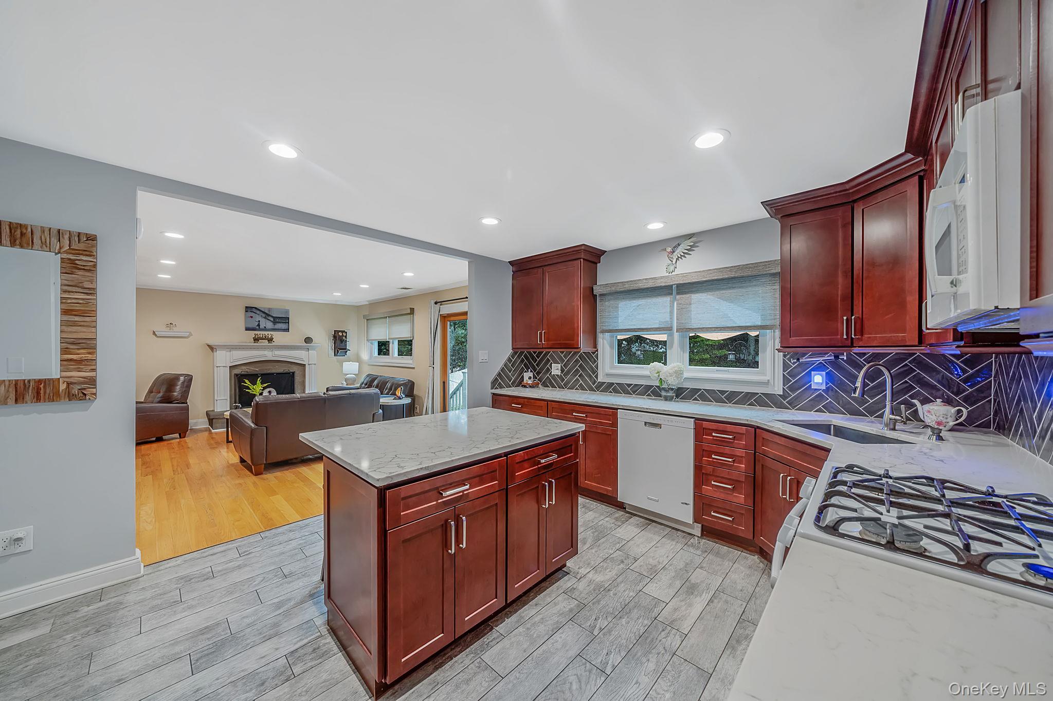 5 Rockhill Road Rocky Point, NY 11778 - Photo 9 of 48 Kitchen featuring cherry-finish cabinetry, light-toned countertops, and a herringbone-patterned tile backsplash