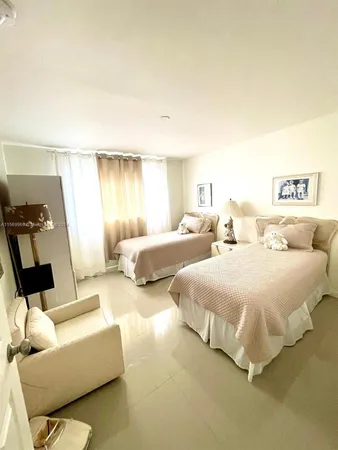 a spacious bedroom with two beds and painting on the wall