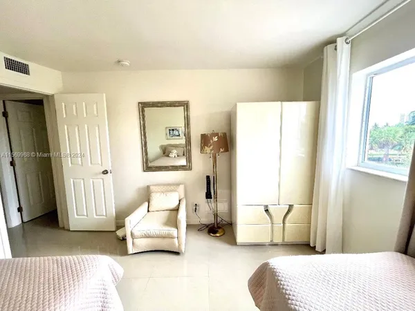 a bedroom with furniture and a large window