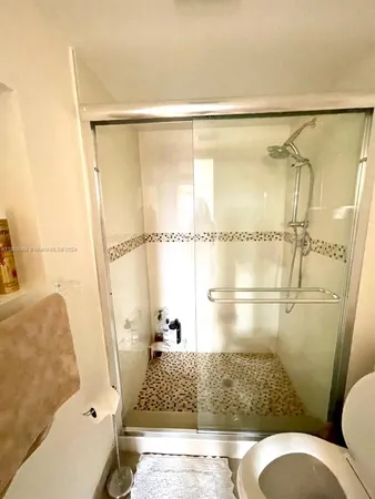 a bathroom with a shower toilet and sink