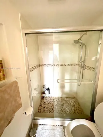 a bathroom with a shower toilet and sink