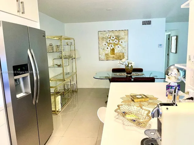 a living room with stainless steel appliances furniture and a large window