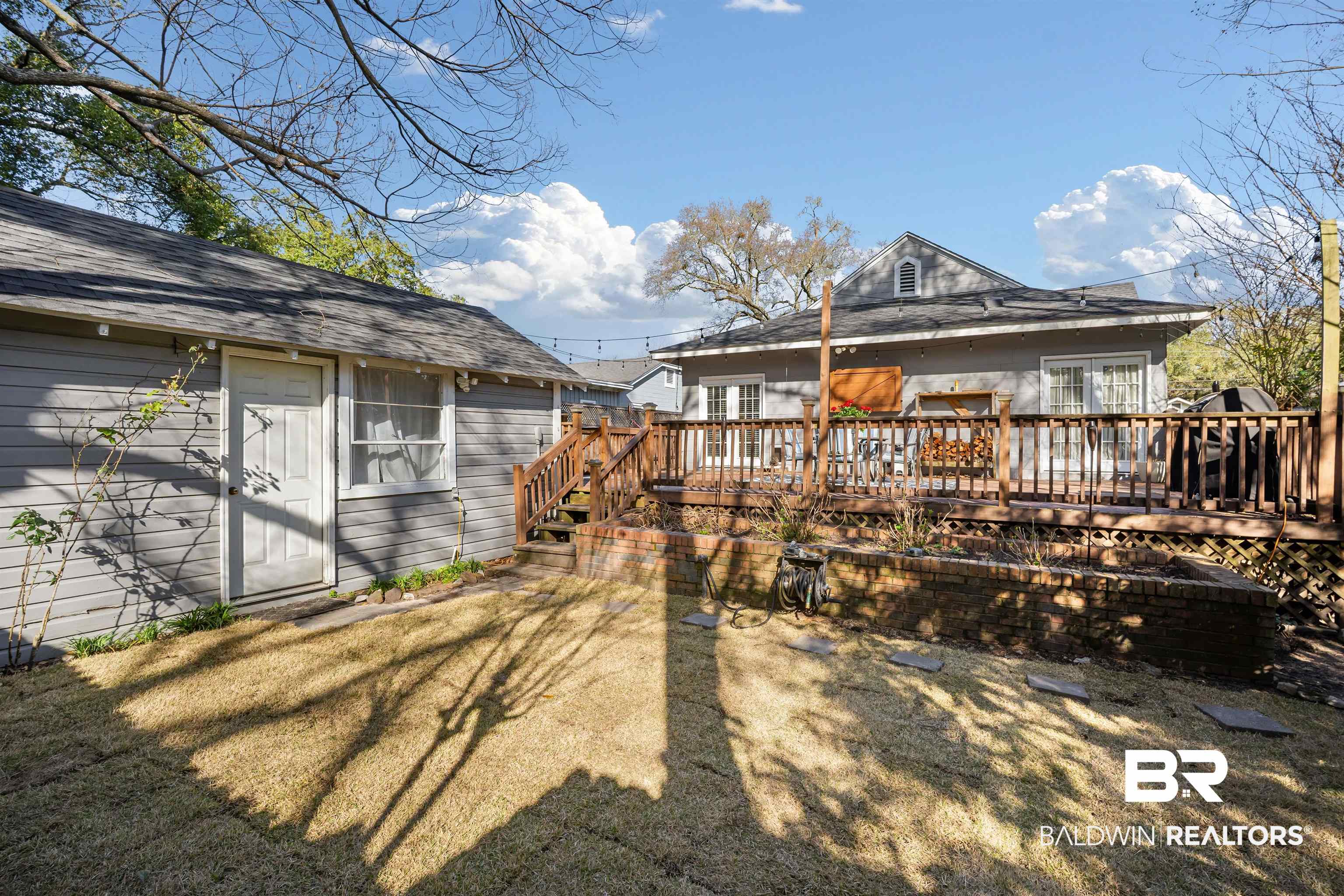 168 Mohawk Street Mobile, AL 36606 - Photo 30 of 31 Rear view of property featuring a wooden deck, a shingled roof, and a lawn