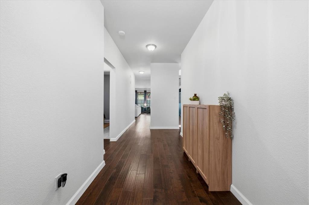 3413 Westfork Ranch Road Fort Worth, TX 76262 - Photo 4 of 35 Hallway featuring wood-finish flooring, white painted walls, recessed lighting, and a built-in wooden cabinet