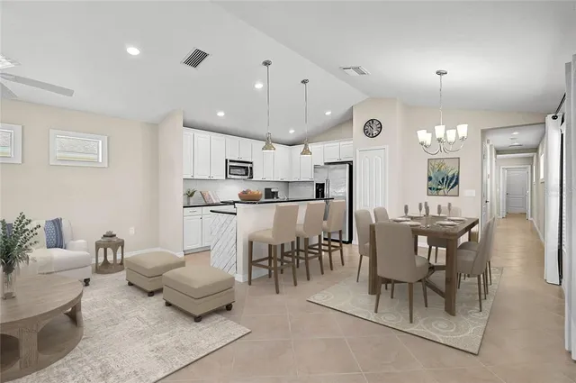 a large kitchen with kitchen island a refrigerator a counter space a sink and a refrigerator