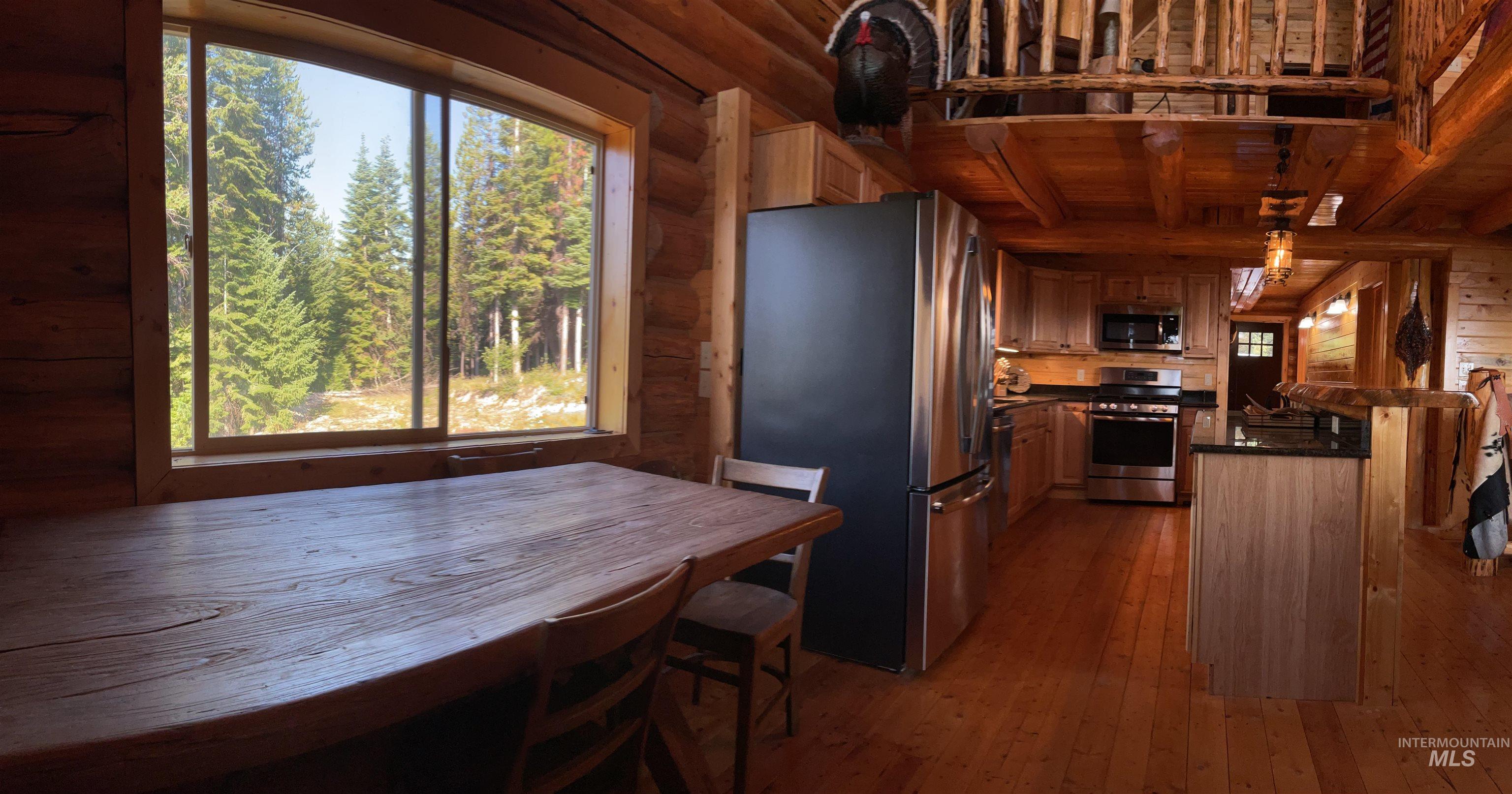 625 Rhett Creek Road Elk City, ID 83525 - Photo 22 of 48 Rustic wood balcony with log railing, supported by robust log columns, offering expansive mountain scenery and a dense forest panorama