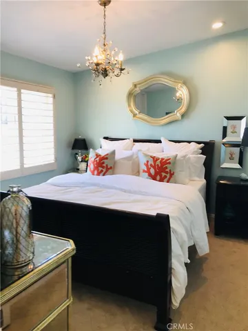 a bedroom with a large bed and a chandelier