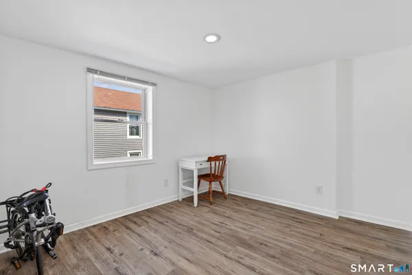 a view of a room with wooden floor lounge chair and windows