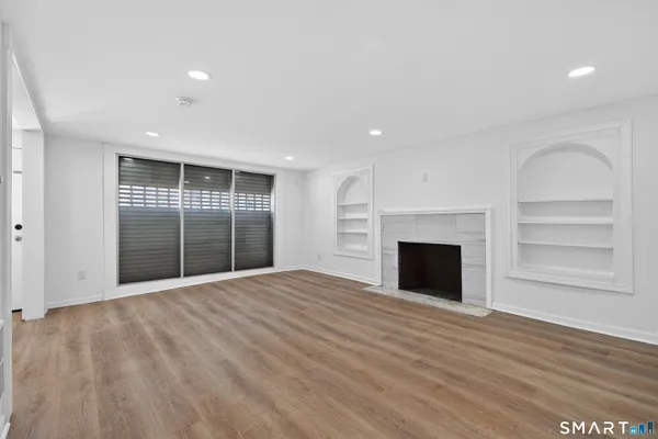a view of an empty room with a fireplace and a window