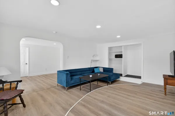 a living room with furniture and a wooden floor