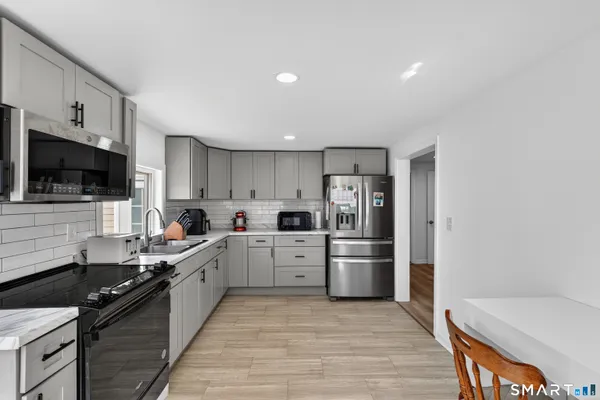 a large kitchen with a stove and a refrigerator