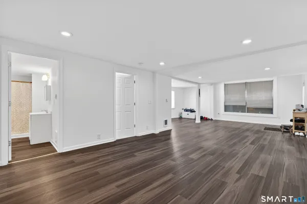 a view of empty room with wooden floor and window