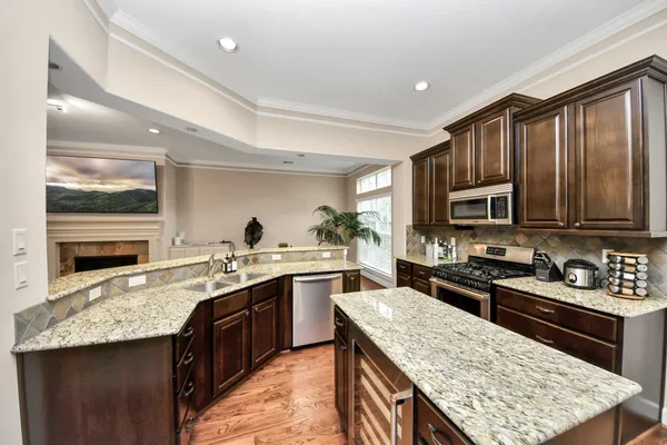 a kitchen with stainless steel appliances granite countertop a sink stove microwave and refrigerator