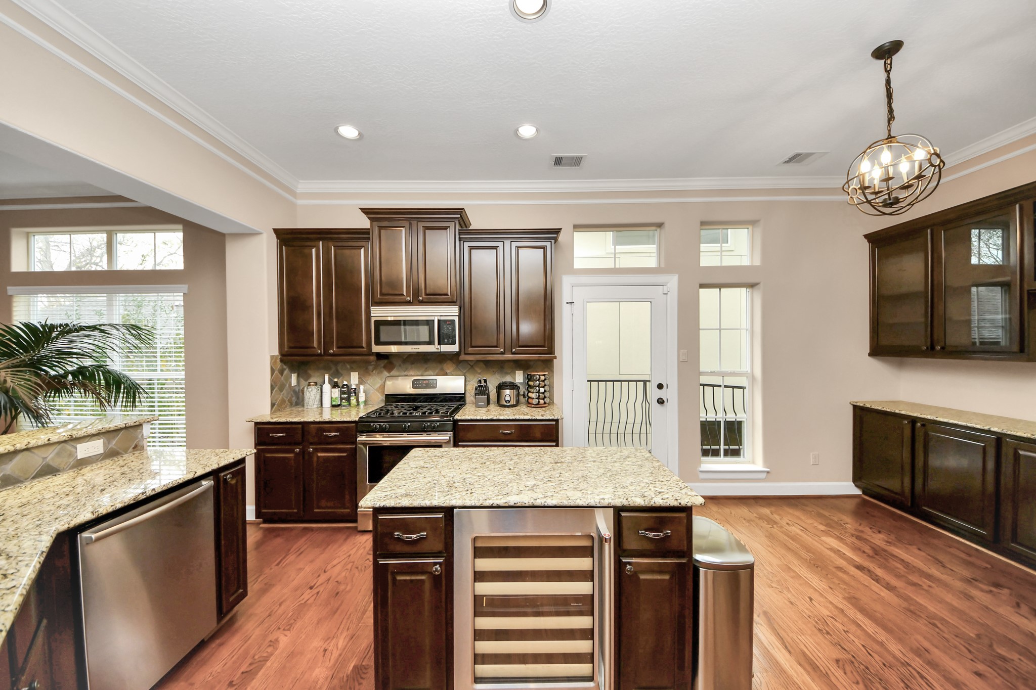 4506 Feagan Street, Unit B Houston, TX 77007 - Photo 16 of 35 a kitchen with stainless steel appliances granite countertop a stove top oven a sink dishwasher a dining table and chairs with wooden floor