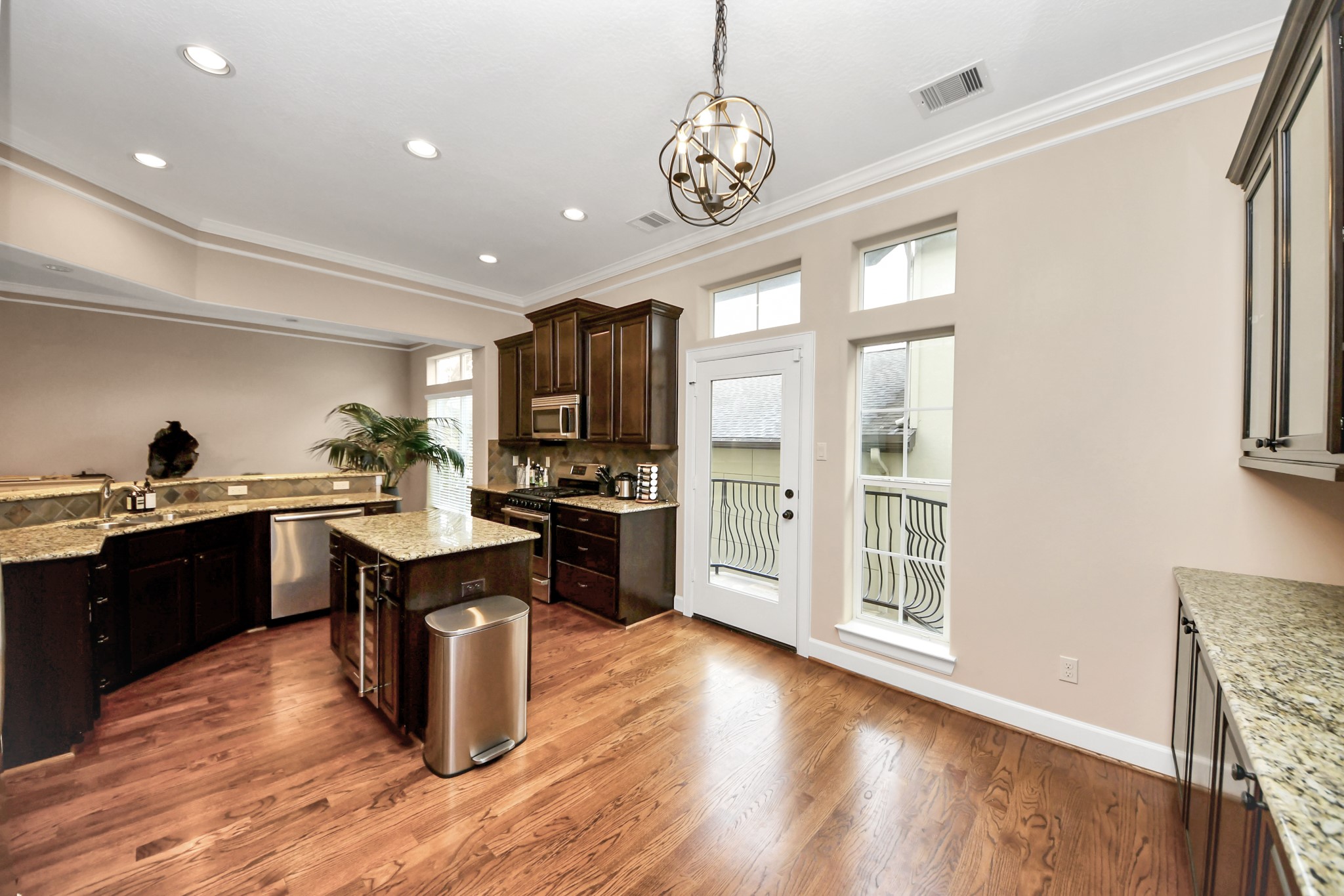 4506 Feagan Street, Unit B Houston, TX 77007 - Photo 22 of 35 a kitchen with granite countertop a stove top oven a sink dishwasher a dining room with fireplace and wooden floor
