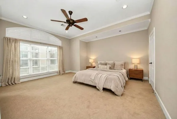 a spacious bedroom with a bed and ceiling fan