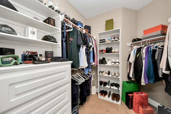 a view of walk in closet with clothes and shoes